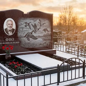 Гранитный памятник охотнику в форме арки с уткой в полёте